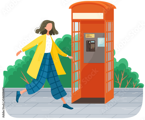 Girl walking in park, payphone stands on sidewalk in street near green trees. Park symbol red opened street phone . Empty London classic telephone booth with an open door, woman strolls alone