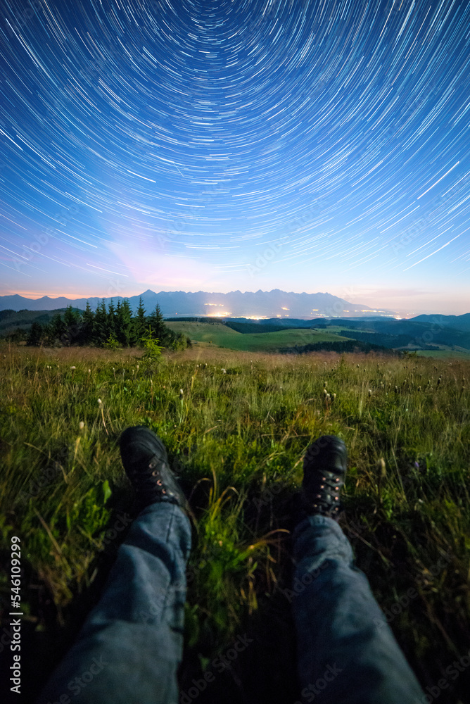 Night view of High Tatras from Panska Hola, Low Tatras National Park Slovakia.Green meadows and mountains in the background. Sitting under the night sky. Startrails Night view of High Tatras from Panska Hola, Low Tatras National Park Slovakia.Green meadows and mountains in the background. Sitting under the night sky. Startrails