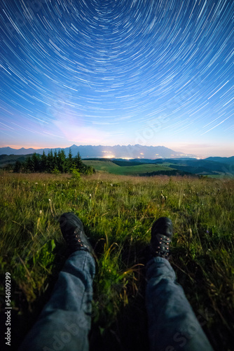 Night view of High Tatras from Panska Hola, Low Tatras National Park Slovakia.Green meadows and mountains in the background. Sitting under the night sky. Startrails