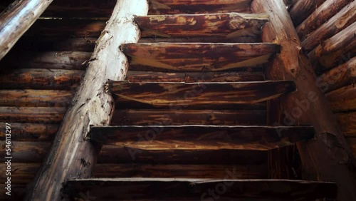 Old brown rough log rustic stairwell descending into darkness. High quality 4k footage