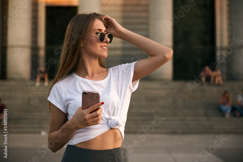 Girl looking to a side wearing sunglasses during a sunset.