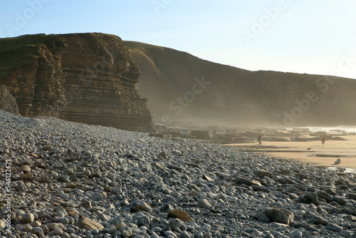 Dunraven Bay, Wales, United Kingdom, Great Britain. Layers of limestone and shale cliffs and sedimentary rocks from the carboniferous period at the Atlantic coast in hazy weather. photo