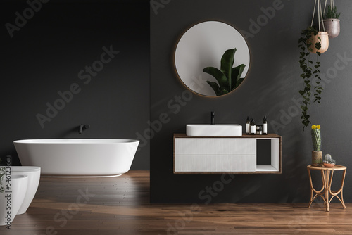 Stylish dark bathroom interior with black walls  white basin with oval mirror  bathtub  shower  plants and dark parquet floor.Minimalist cozy bathroom with modern furniture. 3D rendering