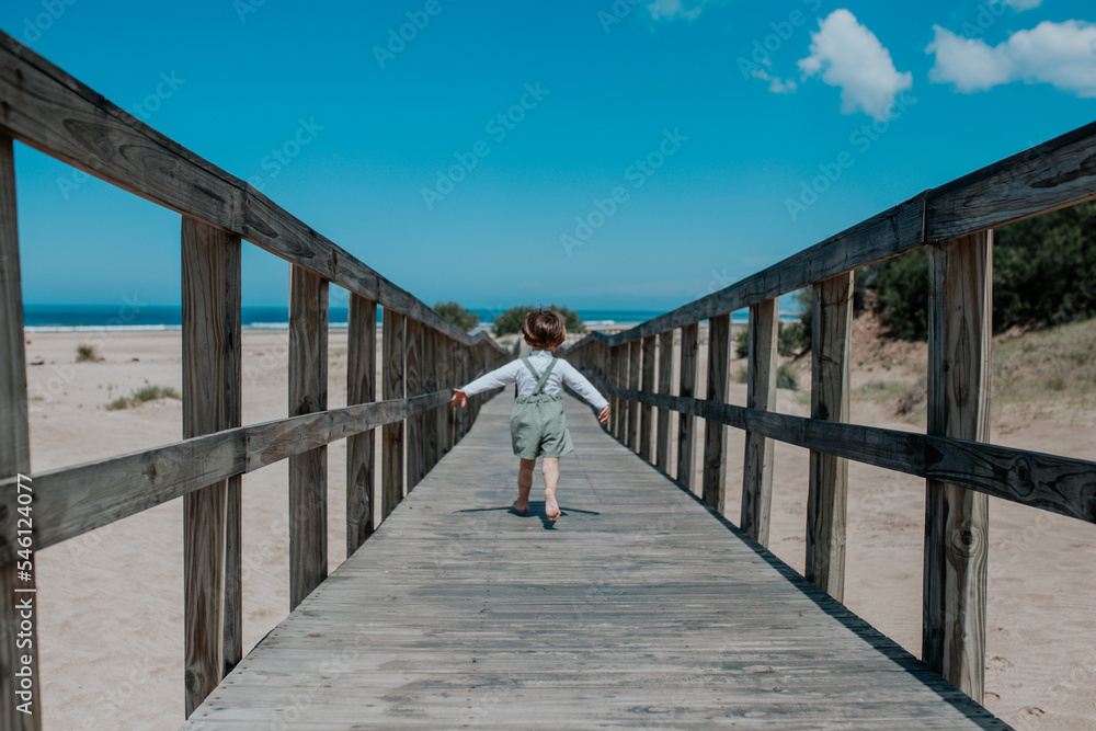 Boy playing on a wooden bridge