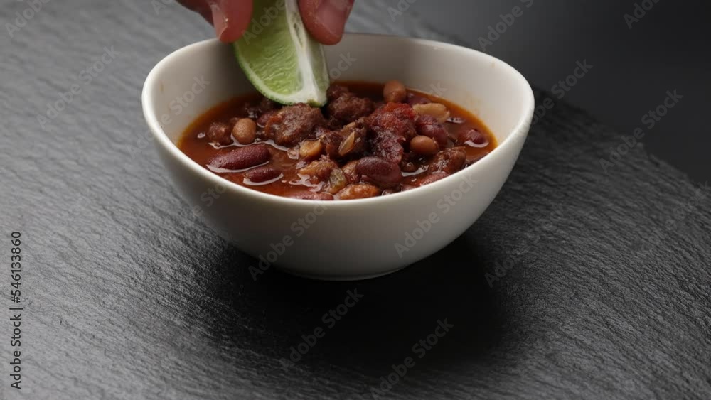 Garnishing a bowl of homemade chili with a slice of lime Garnishing a bowl of homemade chili with a slice of lime