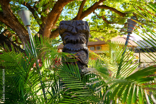 Kapolei, Hawaii / February 23, 2022 : Wooden statue of a tiki god at the Paradise Cove Luau in Ko Olina, a touristic area on the western shore of O'ahu island in Hawaii, United States photo