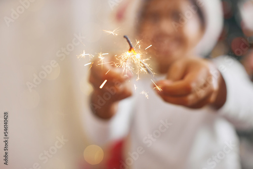 Adorable boy dark skin color in festive costume entertaining with Bengali lights
