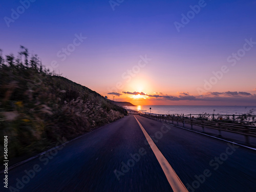 POV shot of driving through the woods and up a slope along the coast at dawn 