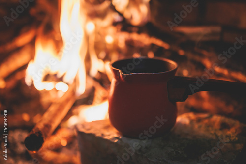 Fotografia Warming up the fire, cozy winter night in the scandinavian cottage house cabin b