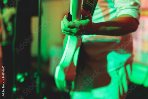 Concert view of a keytar synthesizer player with vocalist and musical jazz rock band orchestra performing in a background, electronic keyboard instrument guitar performer on a stage photo