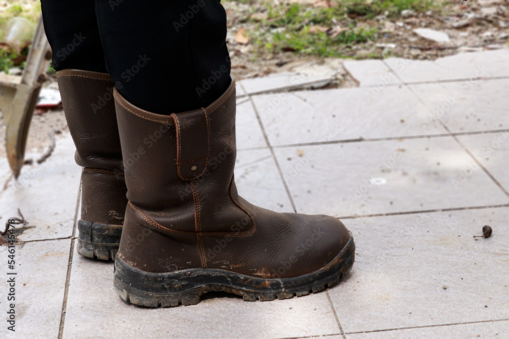 Brown leather safety shoes that are being used by construction workers to protect their feet from work accidents Brown leather safety shoes that are being used by construction workers to protect their feet from work accidents