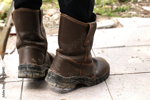 Brown leather safety shoes that are being used by construction workers to protect their feet from work accidents