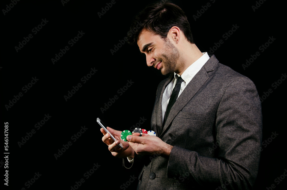 Man playing poker mobile app, cash games, happy satisfied. Dark background Man playing poker mobile app, cash games, happy satisfied. Dark background