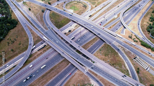 Highway aerial with multiple lanes roads and bridges. High speed car traffic in North America Canada. Transportation traffic at multilevel high speed road complex.