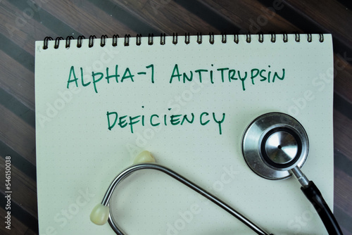 Concept of Alpha-1 Antitrypsin Deficiency write on a book isolated on Wooden Table. photo