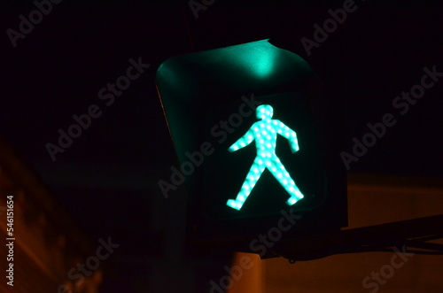 A close look at a green traffic light for pedestrians at night