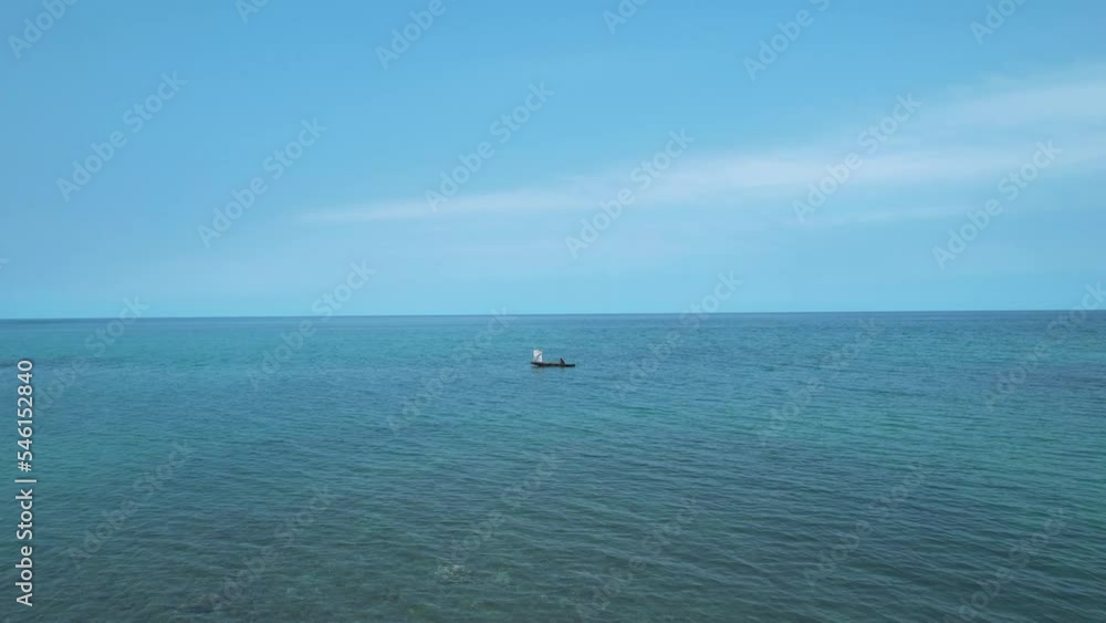 Aerial view over a boy on a artesanal boat, in sunny Morro Peixe, Sao Tome , Africa Aerial view over a boy on a artesanal boat, in sunny Morro Peixe, Sao Tome , Africa