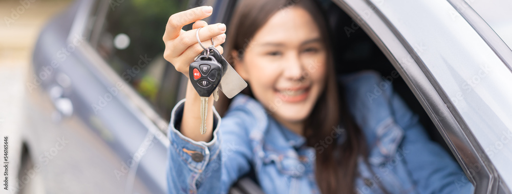 Dealership automobile, smile asian young woman, happy girl sitting in new car after purchase success, showing, holding auto remote key of vehicle, owner driver female buy gift for yourself at showroom