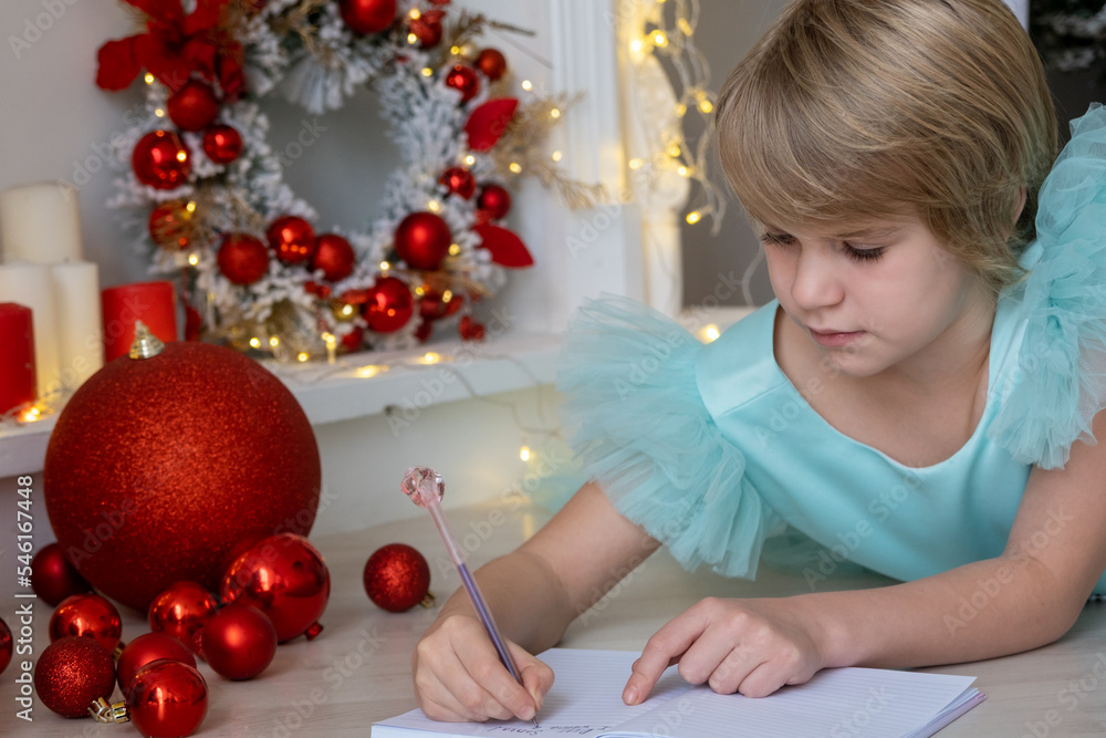 A teenage girl in an evening dress sat comfortably on the warm floor. The child writes a letter to Santa. Child ponders what to ask santa claus.