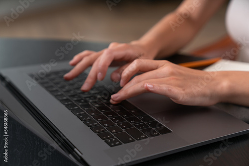 Businesswoman wearing casual wear is sitting typing on laptop