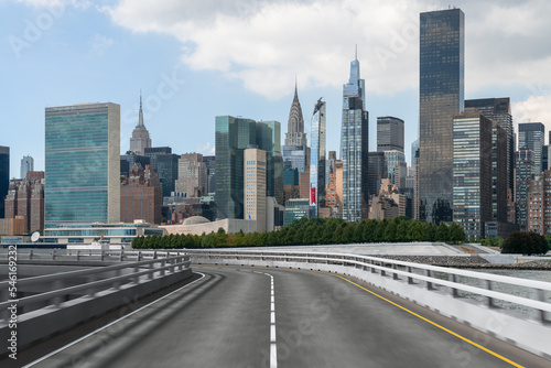 Empty urban asphalt road exterior with city buildings background. New modern highway concrete construction. Concept of way to success. Transportation logistic industry fast delivery. New York. USA.