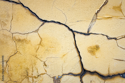 The old wall with cracks remains of yellow plaster.