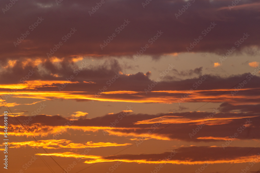 Beautiful background of colorful clouds and texture of a sunset sky in teal and orange colors.