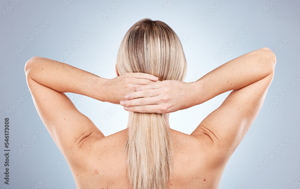 Naklejka premium Blonde, woman and tie hair on back in studio for beauty, cosmetics and wellness against blue background. Model, hair care and health for cosmetic shine, natural and healthy self care by backdrop