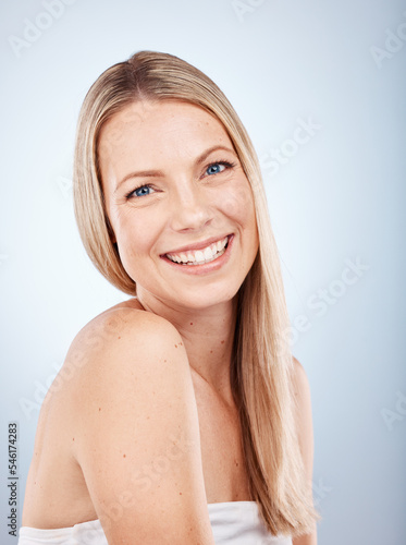 Hair care  beauty and portrait of a happy woman in a studio for wellness  long and healthy hair. Cosmetic  health and girl model from Australia with a blond hair style isolated by a gray background.