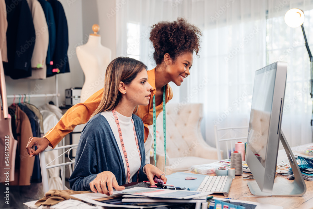 Fototapeta premium Fashion design concept, young stylish woman fashion designer working in studio office, small business owner creating new fashion design cloth in atelier.