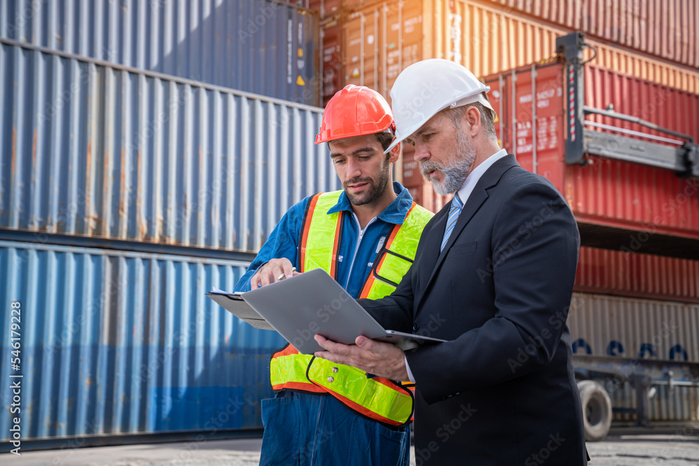 Container yard manager with safety hat talking to foreman about the goods inside the warehouse, Logistics business, Import and export concept. Container yard manager with safety hat talking to foreman about the goods inside the warehouse, Logistics business, Import and export concept.