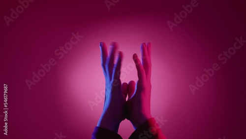 Wait answer. Hand expression. Visual gesture. Female palms holding together shaking fingers feeling impatience on neon light pink blue background.