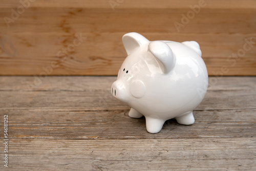 White piggy bank on the wooden background