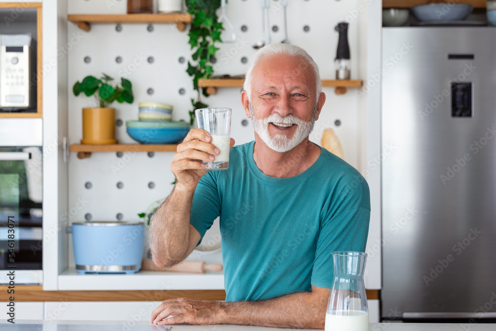 Senior man drinking a glass of milk with a happy face standing and smiling. Handsome senior man drinking a glass of fresh milk in the kitchen Senior man drinking a glass of milk with a happy face standing and smiling. Handsome senior man drinking a glass of fresh milk in the kitchen