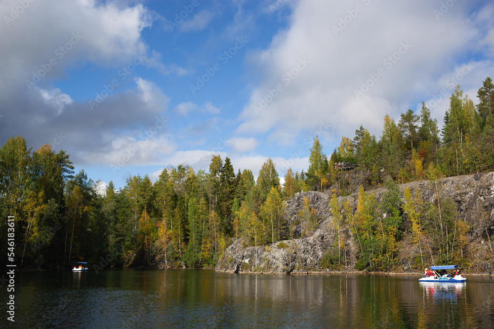 boats floating on the lake in the marble canyon surrounded by autumn forest