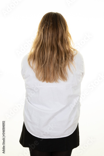 Business blond woman curve standing back against white wall