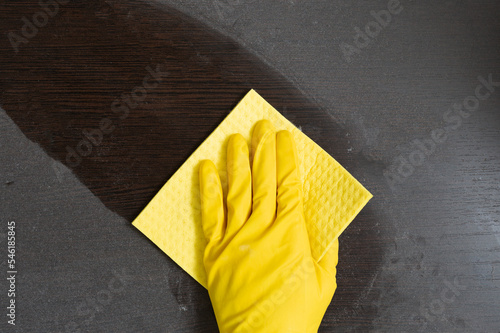 Man in rubber gloves cleans a dusty surface. House and office cleaning. Top view.