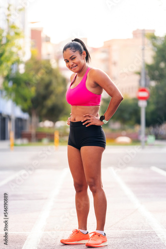 female athlete catching her breath during a break in her training at the city's athletics track, urban sports and healthy lifestyle concept, copy space for text