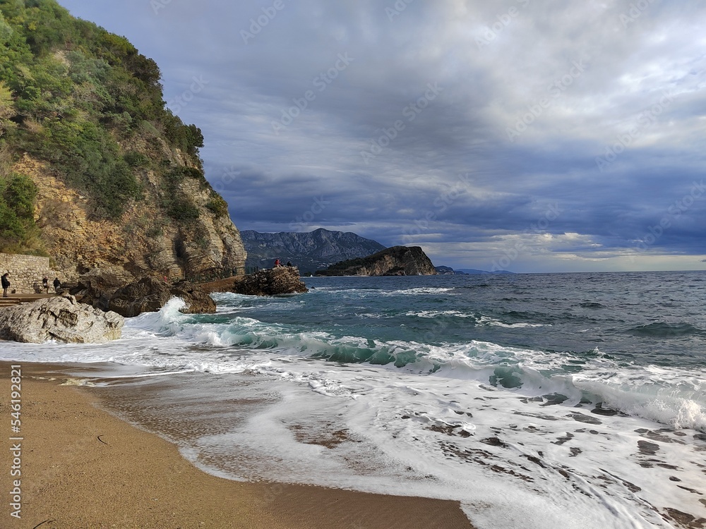 morning after the storm on the beach. beautiful autumn scenery. stones on the sand. big waves on the water. clouds in the sky. wide panoramic view