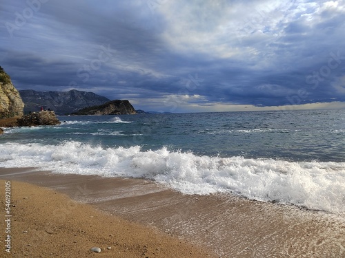 Stormy sea. Morning after the storm on the beach. beautiful autumn scenery. stones on the sand. big waves on the water. clouds in the sky. wide panoramic view