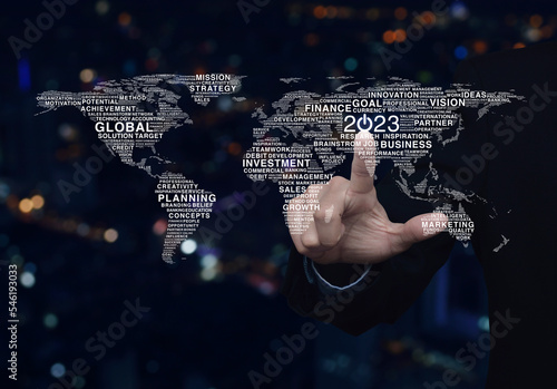 Businessman pressing 2023 start up business icon with global words world map over night city tower, Happy new year 2023 global business start up concept, Elements of this image furnished by NASA