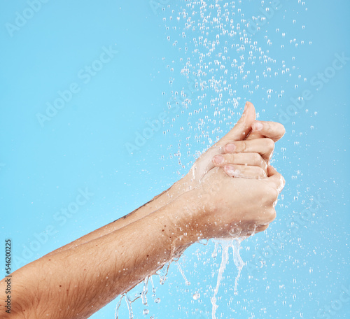 Woman, water splash or washing hands on blue background in studio for hygiene maintenance, bacteria security safety or grooming. Zoom, model or wet cleaning in shower skincare wellness and healthcare