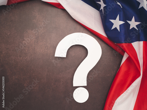 The American flag and a white question mark on a table photo