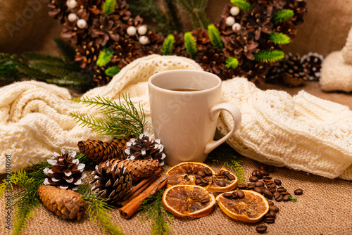 Christmas composition spruce cones, cup, citrus, cinnamon on burlap