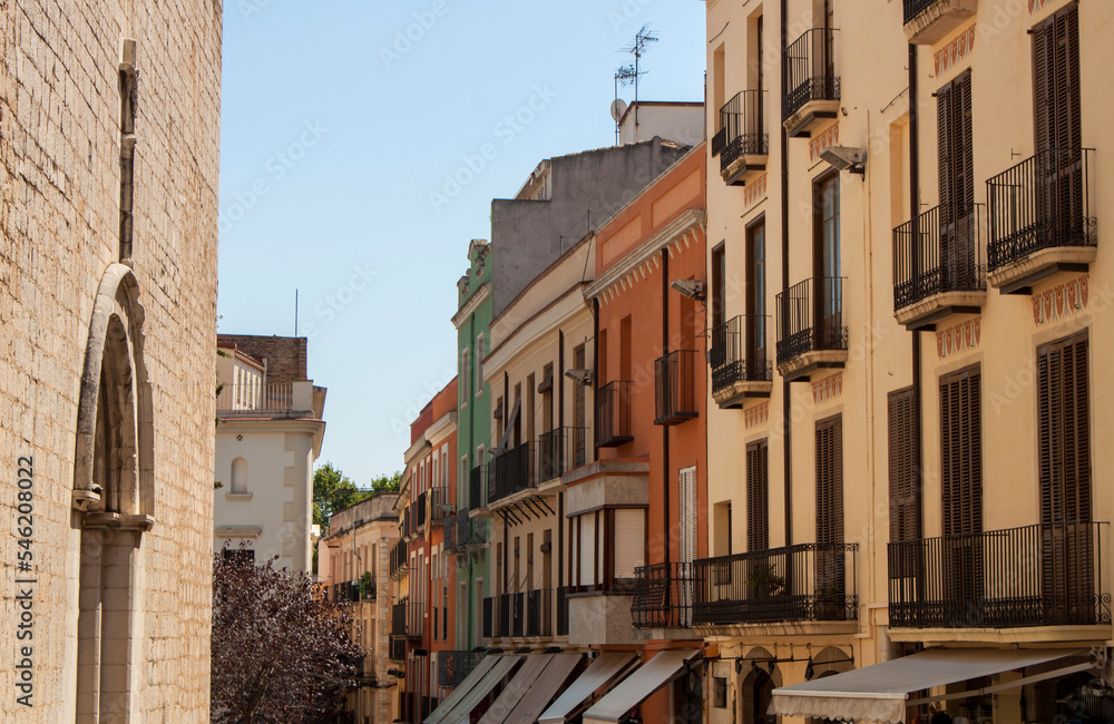 Exterior view of historical buildings in the old town streets of Figueres, the province of Gerona, Catalonia, Spain, Europe. Facades of colorful houses, Spanish Mediterranean downtown neighborhood.