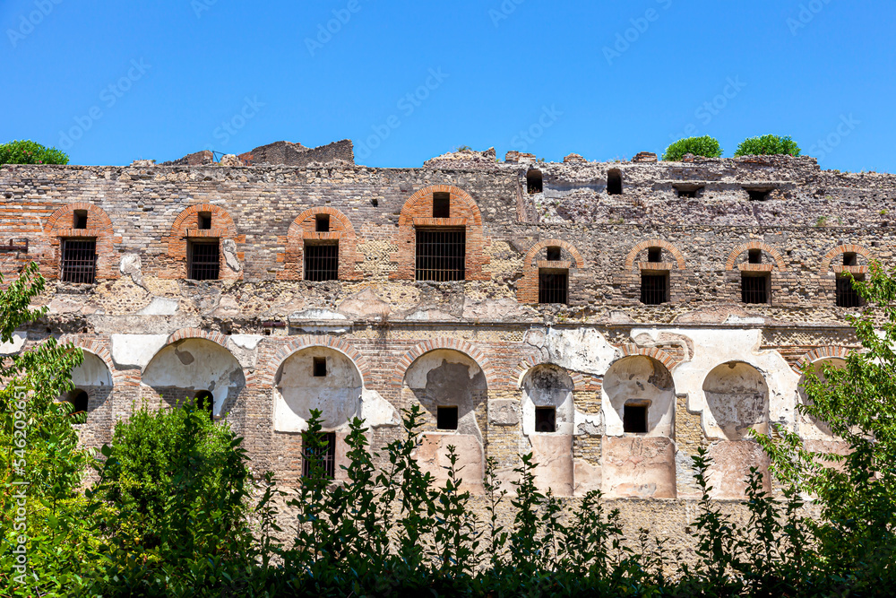 The ancient Roman city of Pompeii was buried under a layer of volcanic ash from the eruption of Mount Vesuvius in 79 AD. A two-story building against a blue sky.