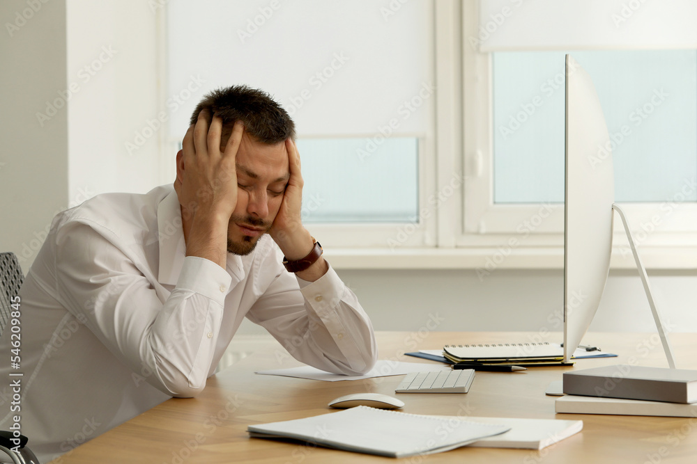 Sleepy man snoozing at workplace in office Sleepy man snoozing at workplace in office