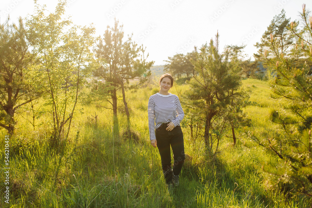 Smiling girl with flowers walking in the woods