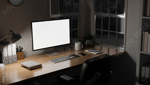 Modern office working desk near the window at night with computer mockup, light from table lamp