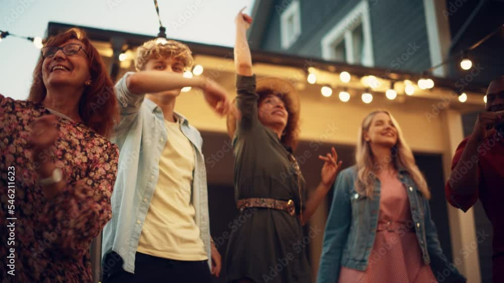 Parents, Children and Multicultural Friends Dancing Together at a Garden Party Disco Event at Home. Young and Senior People Relaxing, Having Fun on a Summer Afternoon. Slow Motion Footage. Parents, Children and Multicultural Friends Dancing Together at a Garden Party Disco Event at Home. Young and Senior People Relaxing, Having Fun on a Summer Afternoon. Slow Motion Footage.